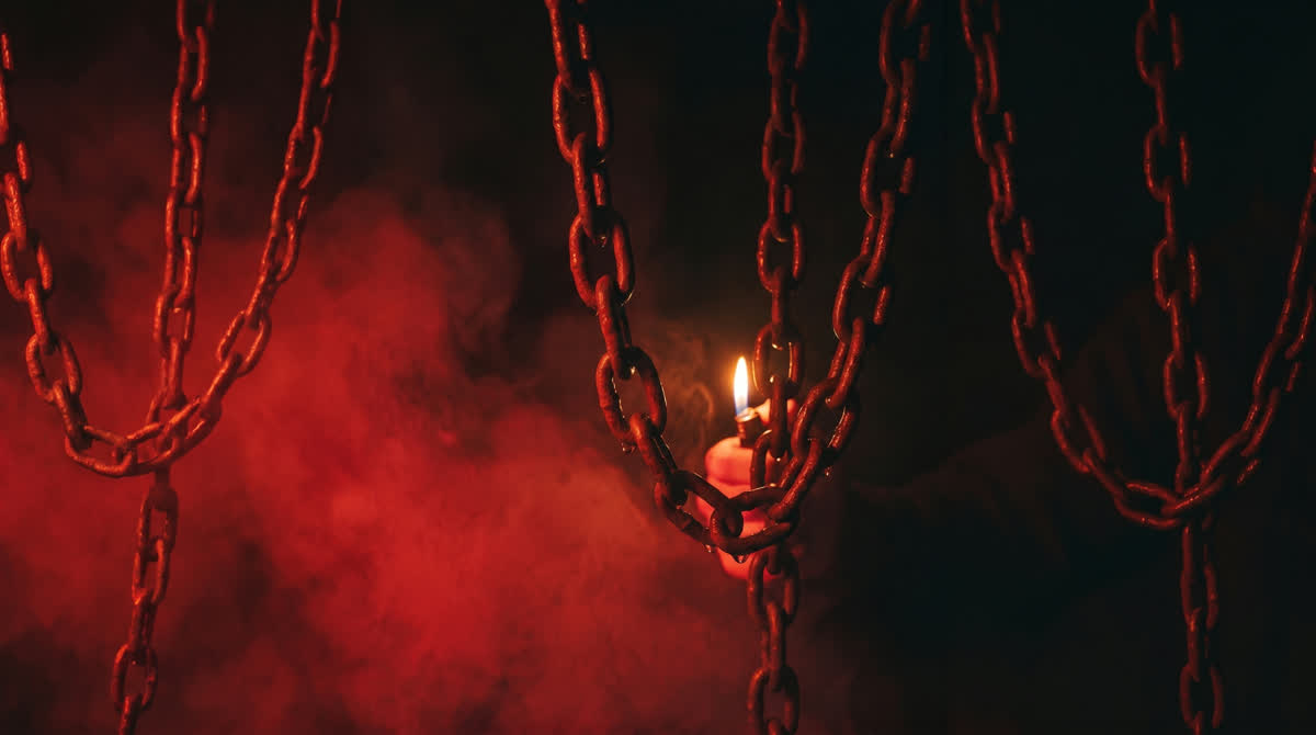 KI-generiertes Motiv: Schwere Metallketten im roten Nebel, dahinter eine einzelne Flamme